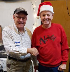 Andy, KD8SCV, congratulates festively dressed Bob, K8RGI, on winning the 50-50 drawing